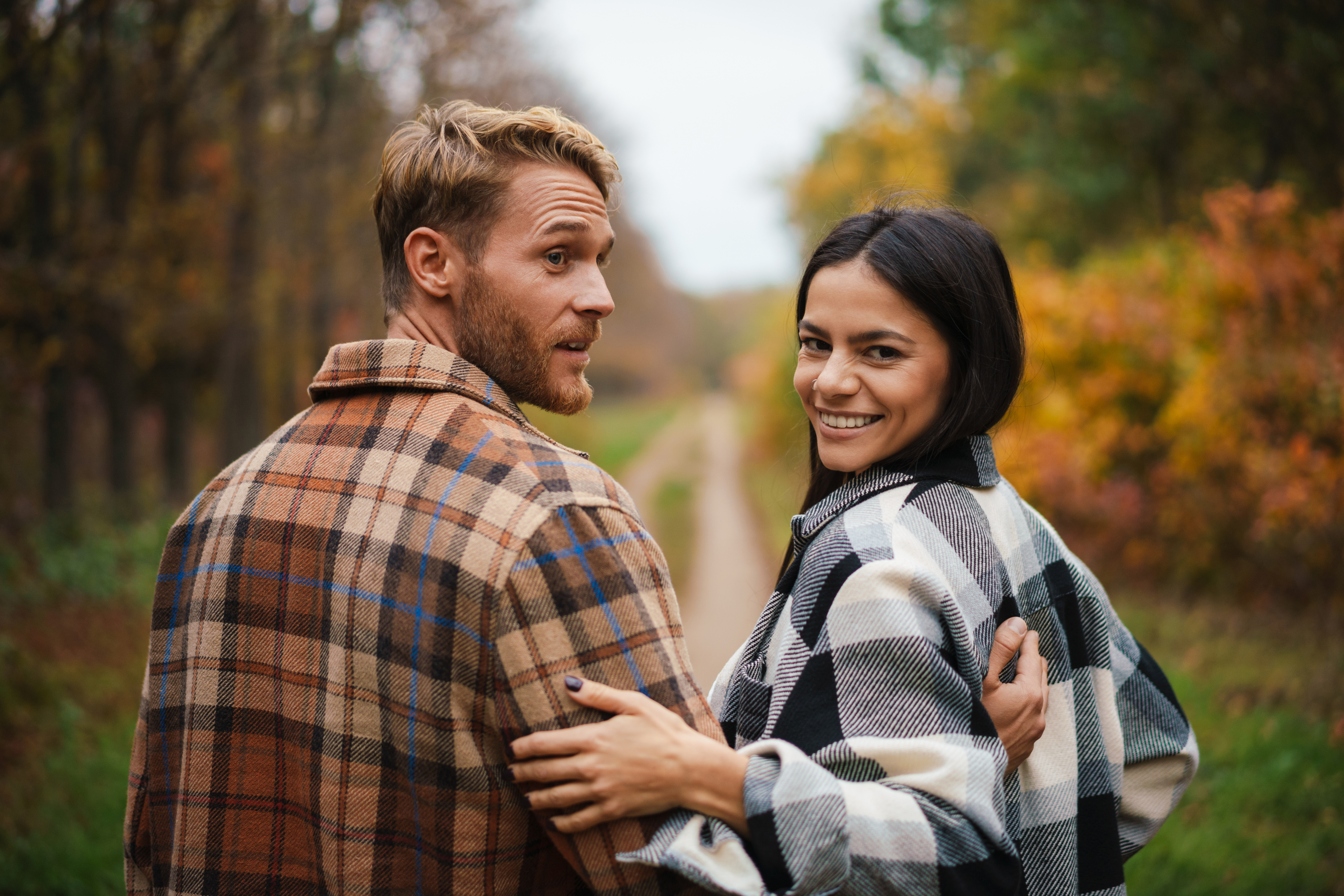 Couple walking together through fall woods